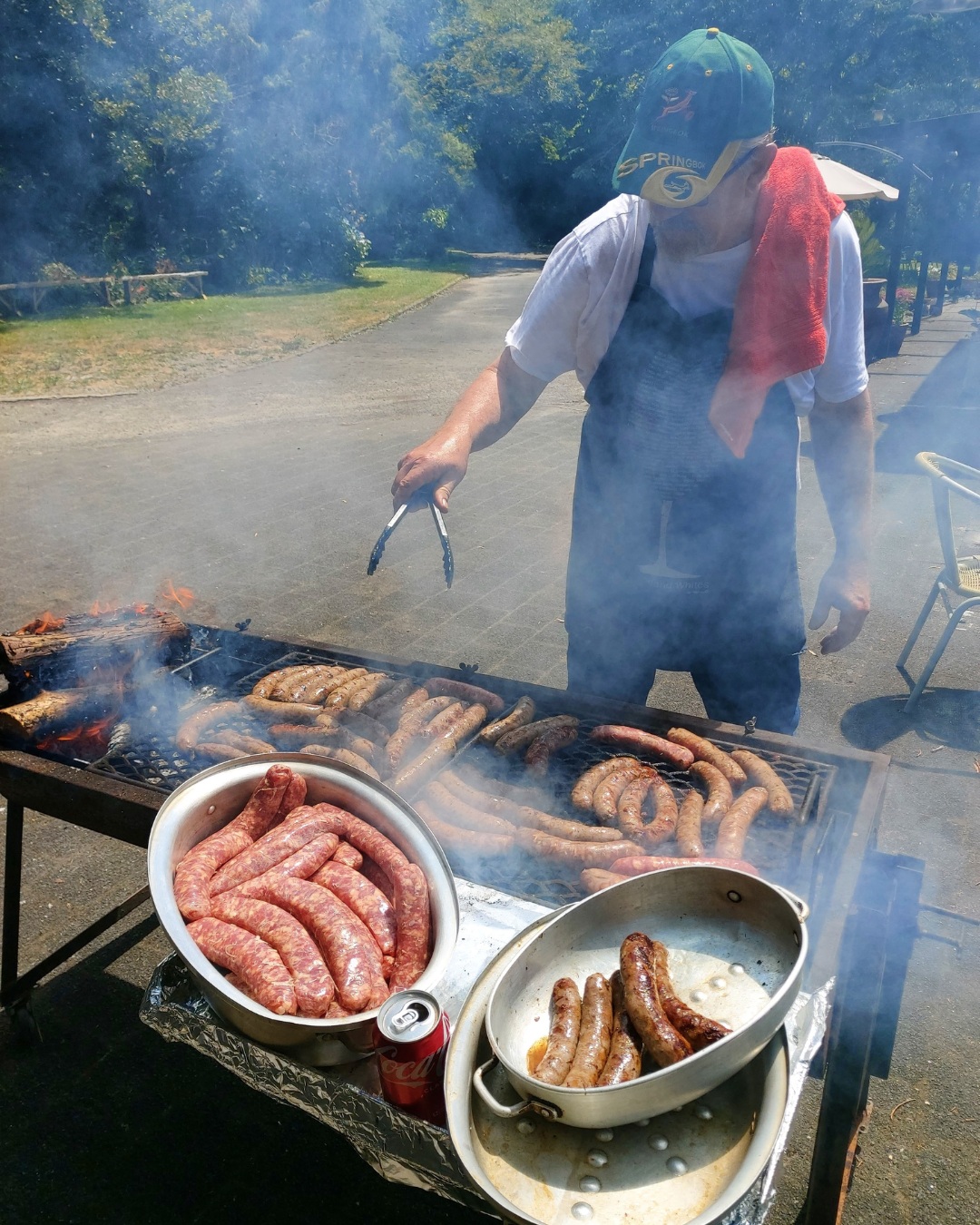Traditional South African braai with boerewors sizzling over open wood fire
